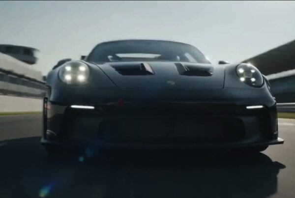 Black Porsche 911 GT3 RS on a race track, front view, AI video frame